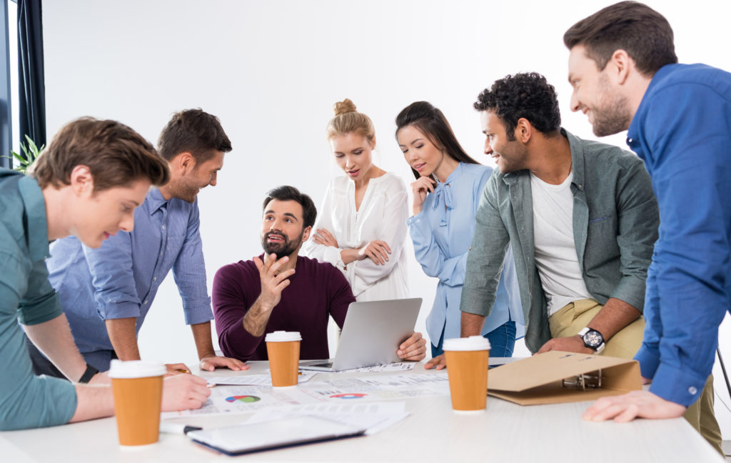 Group of interested-looking people around a computer